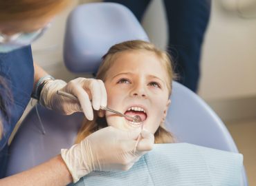 Dentists with a patient during a dental intervention to girl. Dentist  Concept
