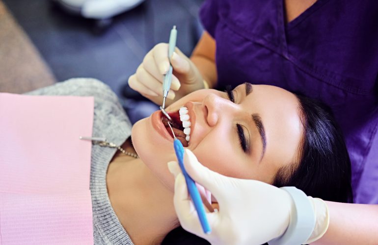 Close-up image of a dentist examining female's teeth in dentistry.